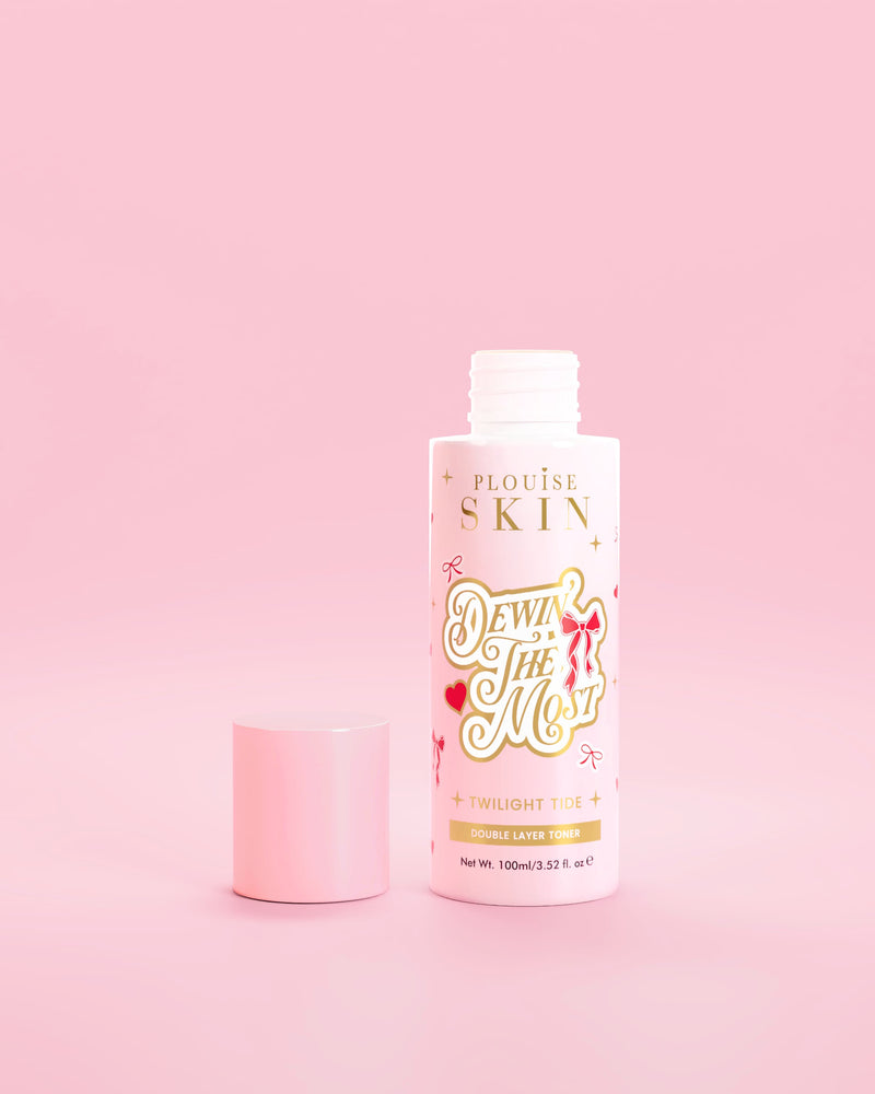 Růžová lahvička P.Louise Dewin The MOst Double Layer Toner s červenou mašlí na růžovém pozadí