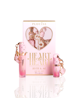 P.Louise Bestie & Me lip oil set, featuring a pink and gold gift box with a heart-shaped window, flanked by two pink gradient lip oil tubes with diamond-patterned caps and keychain charms, on a white reflective surface.