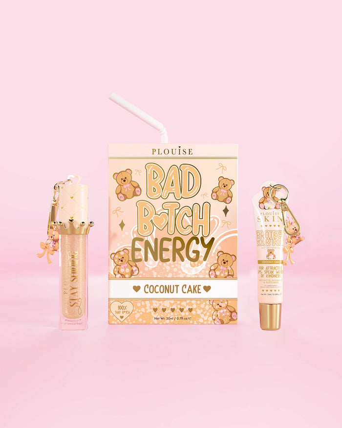Ein P.Louise Teddy Glitter Bad Bitch Energy Lip Duo mit Kokosnusskuchen-Duft, einer Lippenpflege und einem Lippenöl vor einem rosa Hintergrund