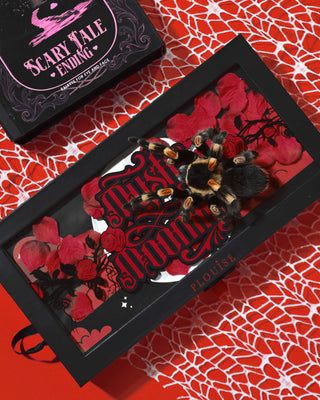 P.Louise Mystic Moonlight Halloween Eyeshadow Palette æske dækket af røde rosenblade og en tarantel på en rød edderkoppespind baggrund
