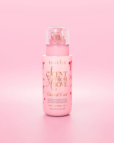 Różowa butelka mgiełki do włosów i ciała „Scent From Above” z grafiką z czerwoną kokardką na różowym tle