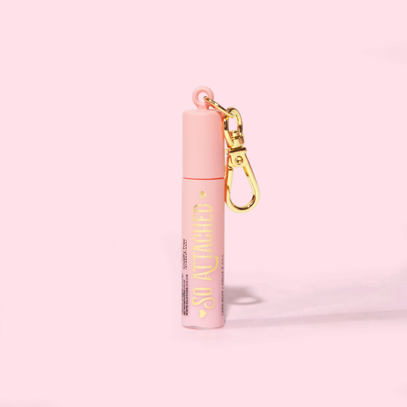 Imagine cu rimelul antiscris P.Louise Mini Keychain într-un tub roz cu scriere aurie și atașament pentru breloc auriu