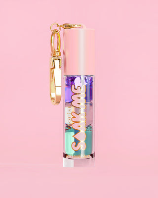 P. Louise Soak Me Lippenöl mit buntem Schichtöl in einer rosa Tube mit goldenem Verschluss auf rosa Hintergrund