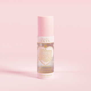 En rosa sprayflaska märkt 'P.Louise SKIN' med en skildring av ett hjärta och några blommiga element, innehållande en återfuktande inställningsspray.