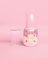 Rosa flaske P. Louise Erase The Trace Dark Spot Correcting Serum med lokket av på en rosa bakgrunn